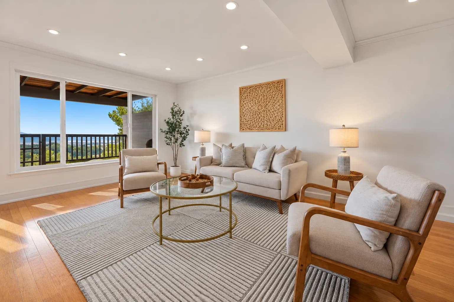Staged San Bruno living room with a glass coffee table, wood armchairs and windows to a deck with a view